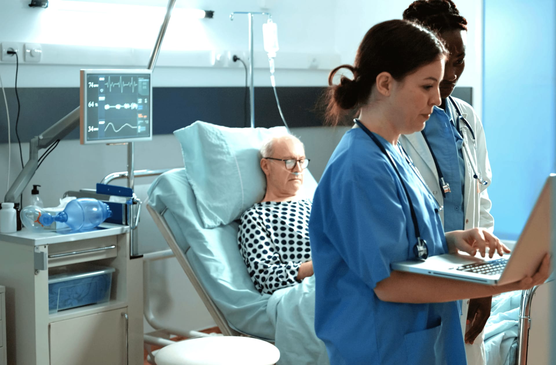 Ein Arzt in der Notaufnahme, der am Krankenbett eines Patienten ein Telemedizin-Tablet nutzt